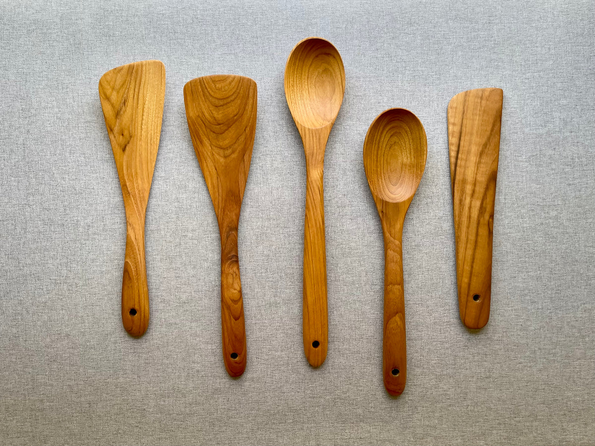 Five-piece teak wood cooking utensil set with spoons and spatulas