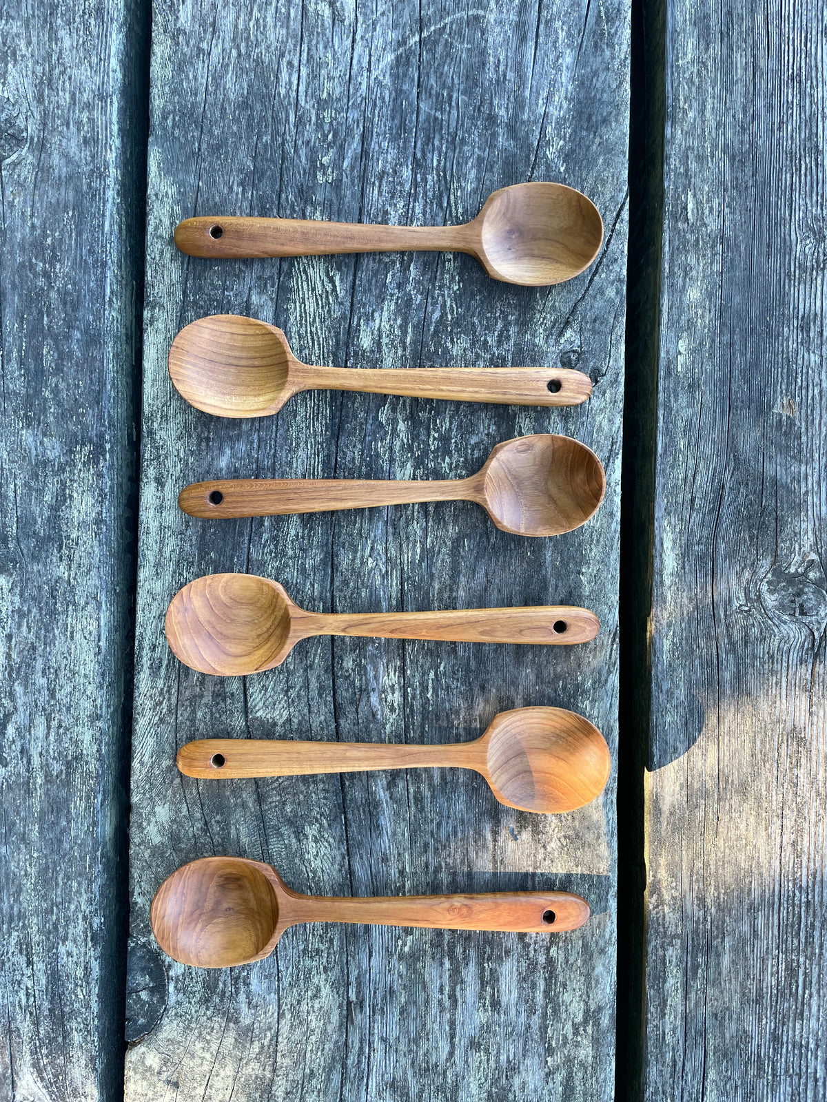 Handmade teak wood serving spoon set of six on weathered wood