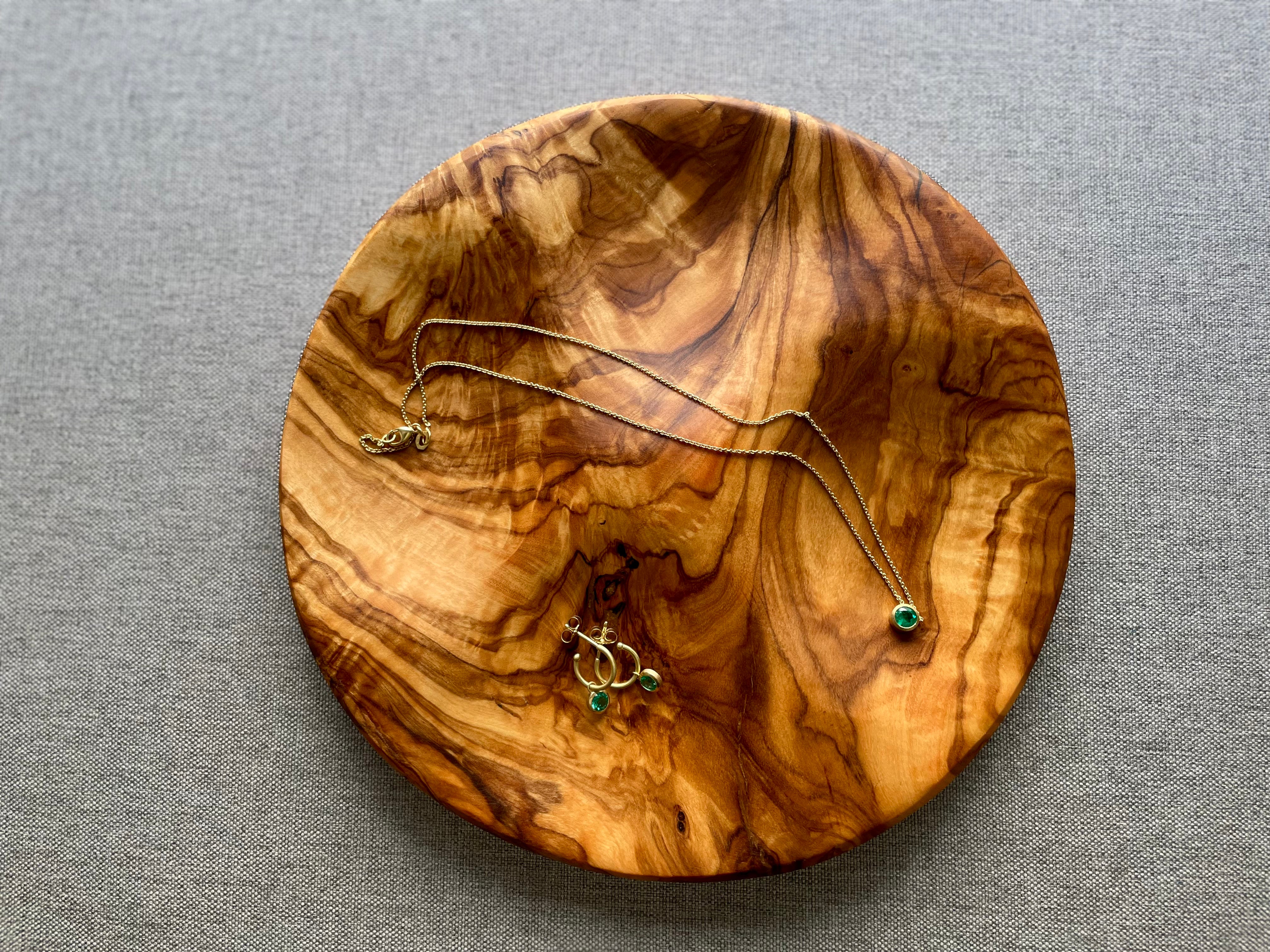 Handmade wavy olive wood jewelry dish holding rings and necklace