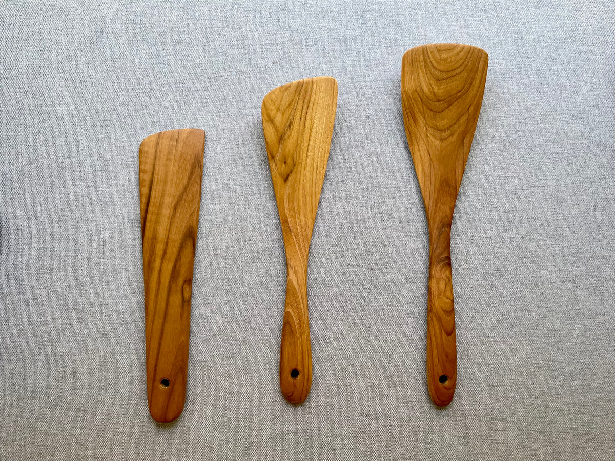 Three-piece teak wood spatula set with golden grain