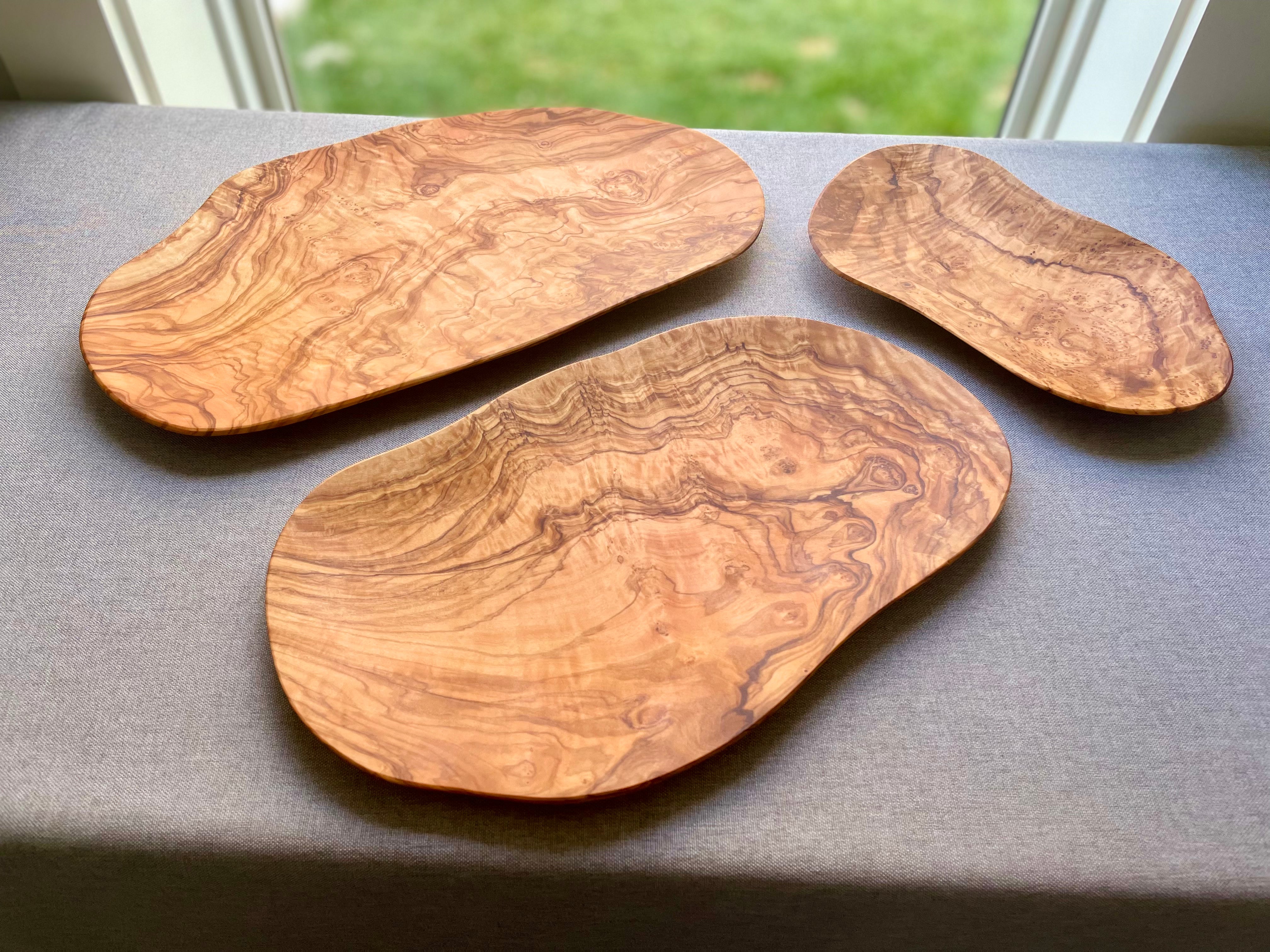 Set of three handmade olive wood charcuterie platters with grain
